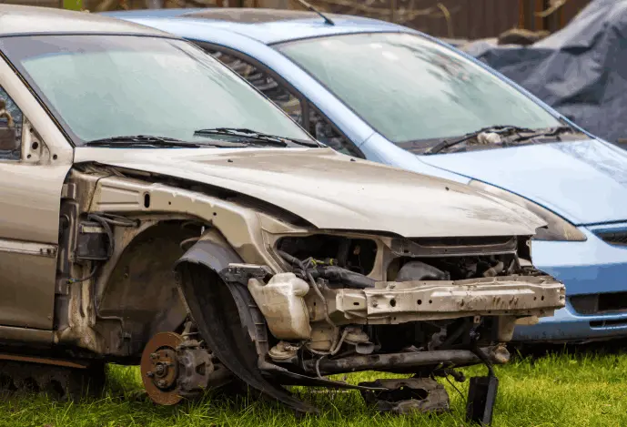 Professional auto wrecker services in Brampton dismantling a silver car for parts.