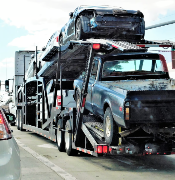 Large flatbed trailer transporting multiple scrap vehicles for recycling in Ontario.